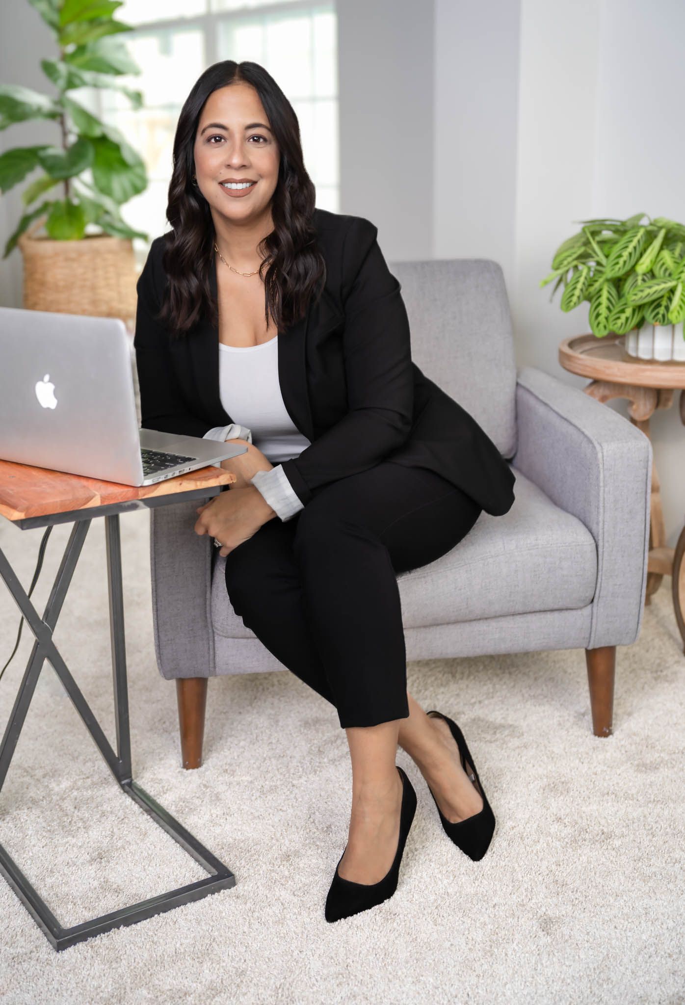 Business professional working on laptop in modern home office setting.
