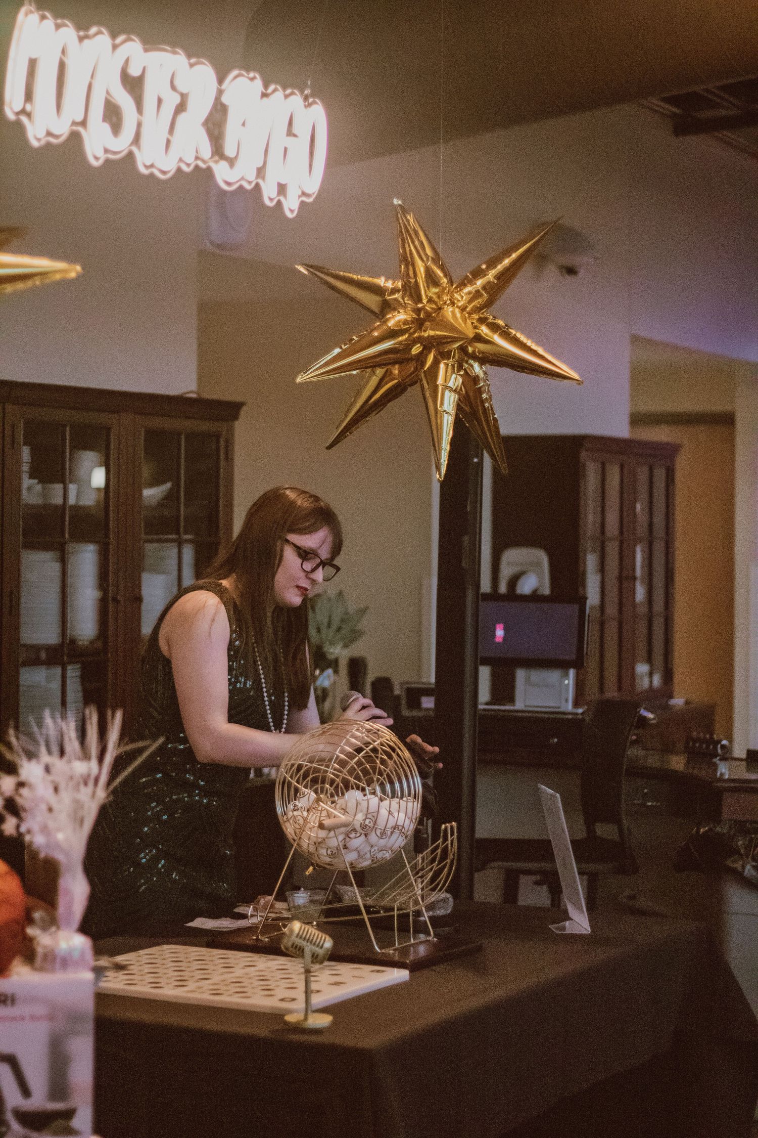 Gold star decorations hang above a dark room with glowing hands display.