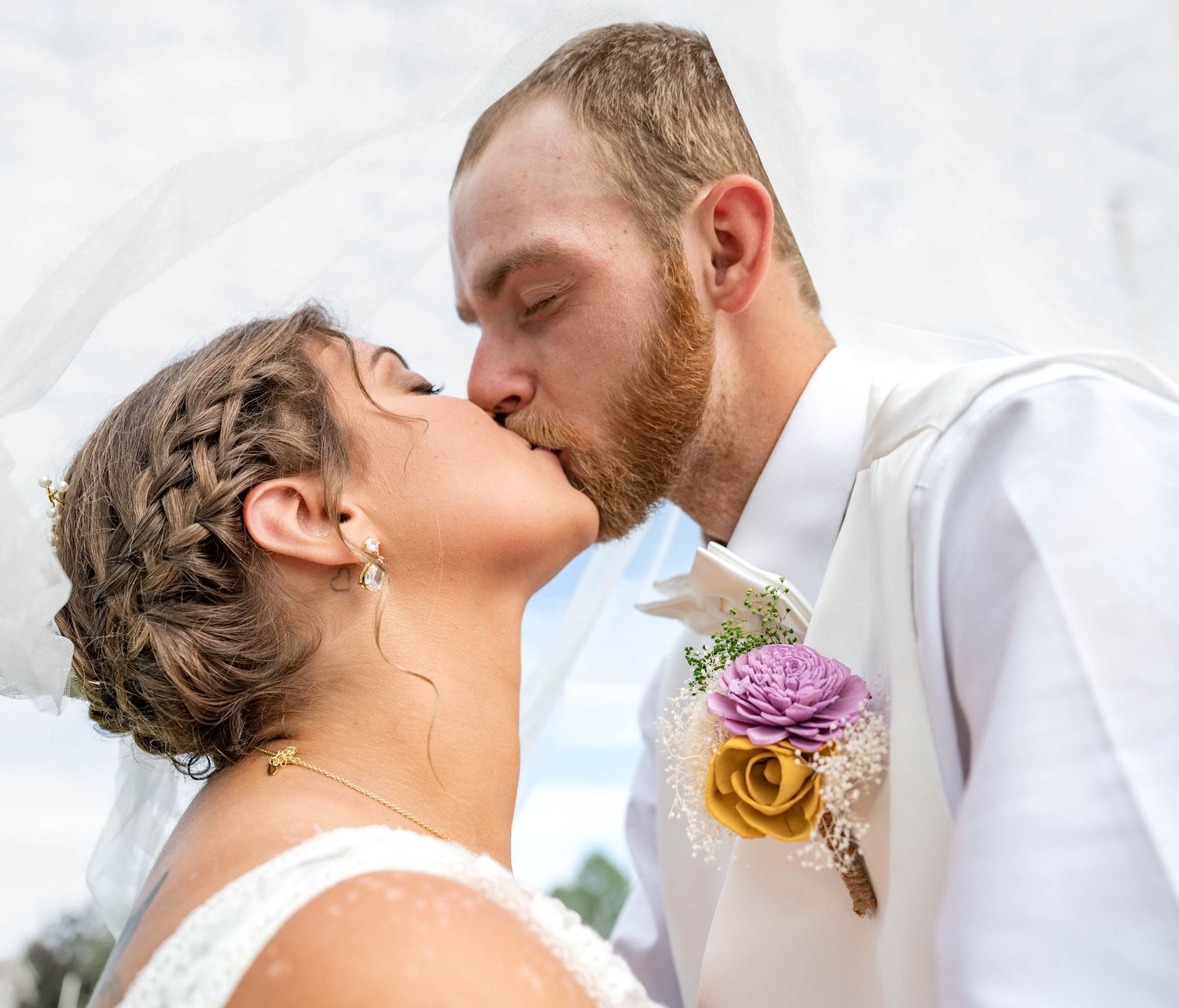 Intimate wedding moment captured with soft lighting and floral boutonniere.