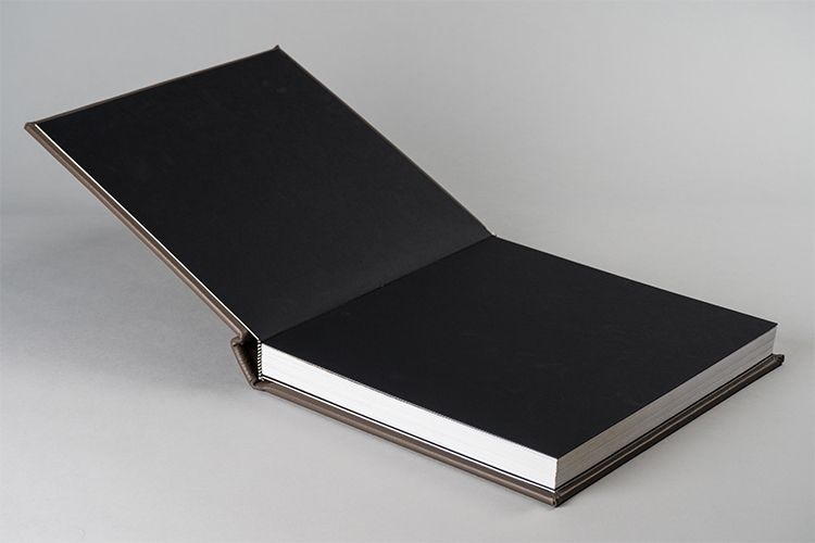 Open black photo album displaying empty pages and professional binding.