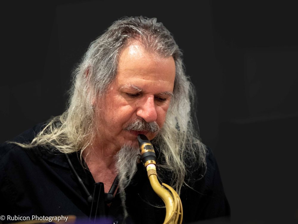 Grey-haired Saxaphonist about to play