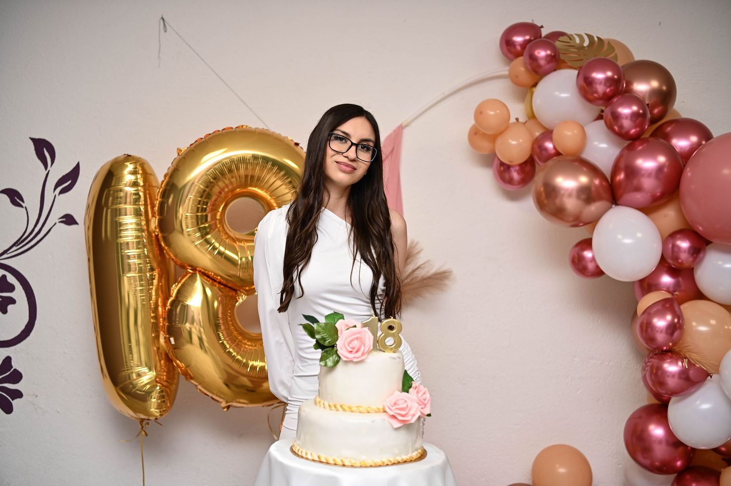18th birthday celebration setup with rose gold balloons, cake and elegant party decorations.