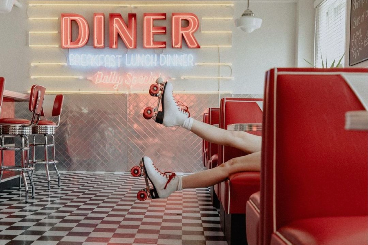 Retro diner interior with red vinyl booths and classic black and white checkered floor pattern.