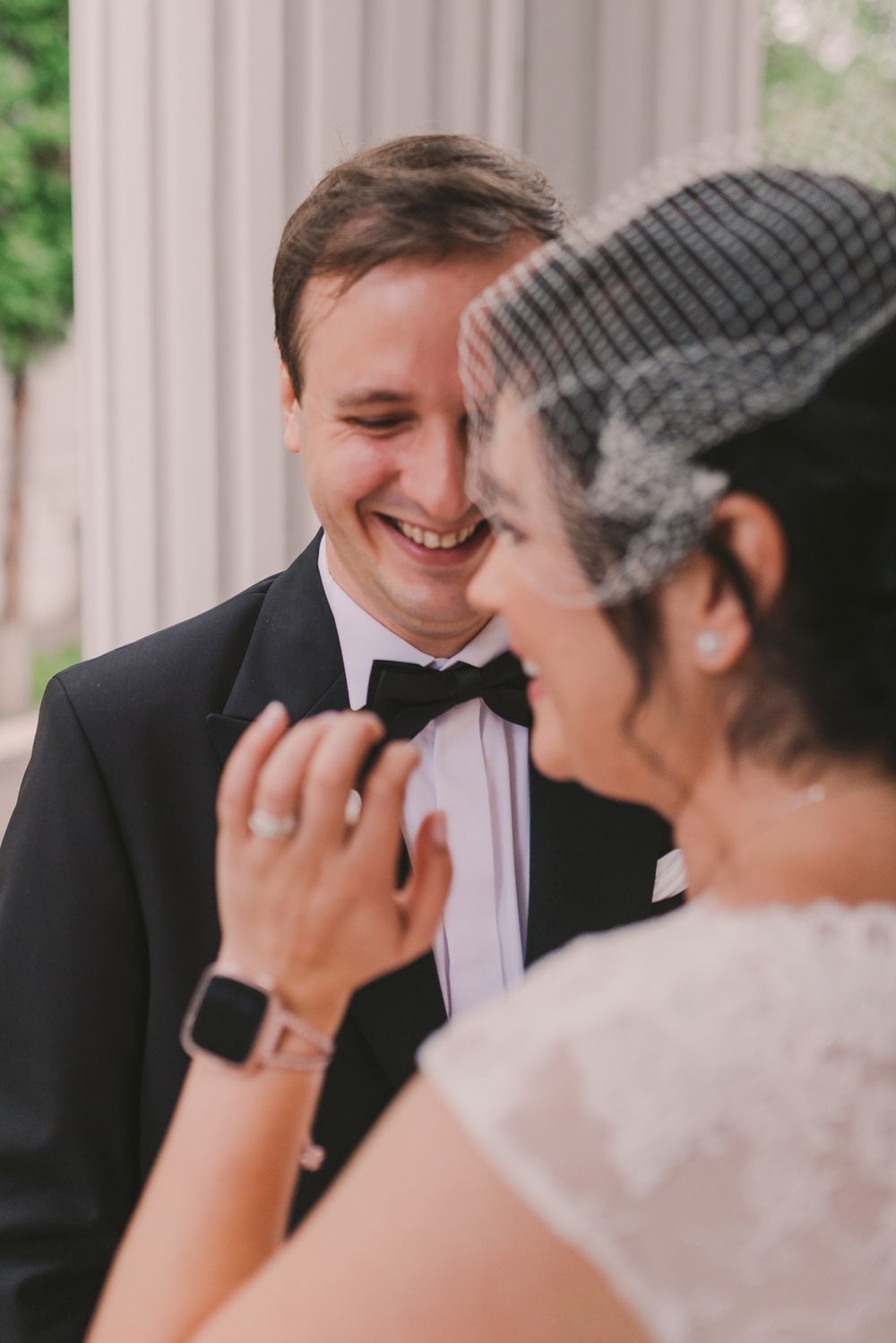 Intimate wedding portrait captured outdoors with classical architecture in the background.