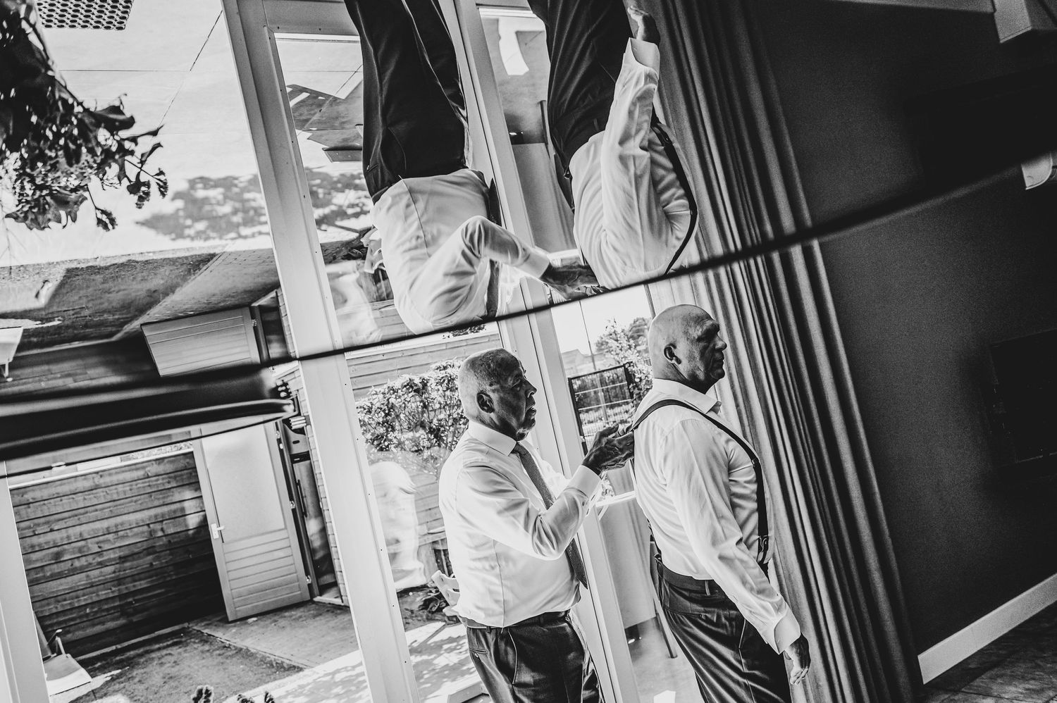 Black and white photo of people walking through a building interior.