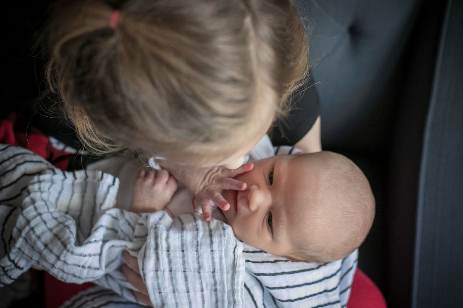Big sister telling her newborn brother a secret story.