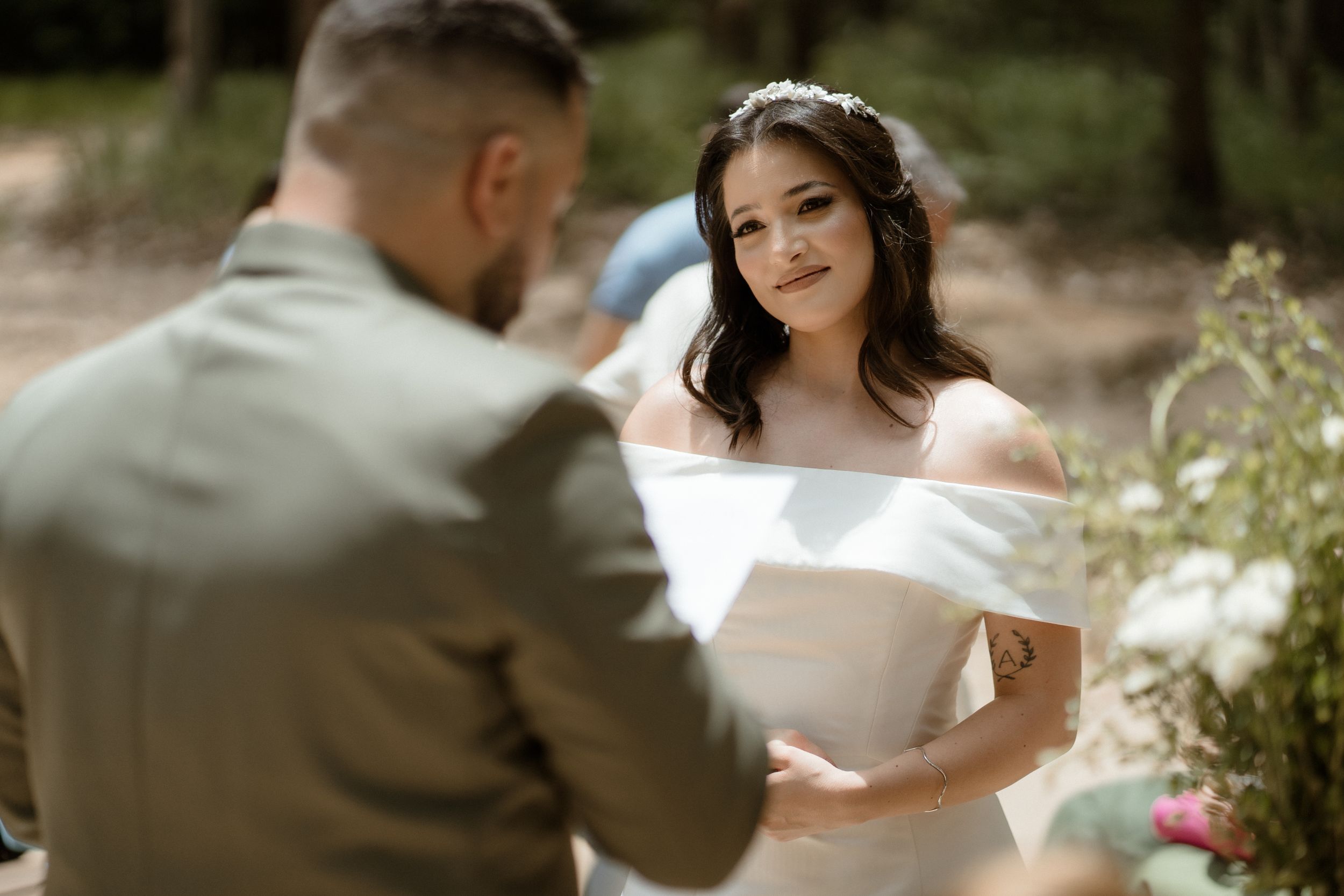 Romantic couple sharing intimate moment during outdoor forest wedding.