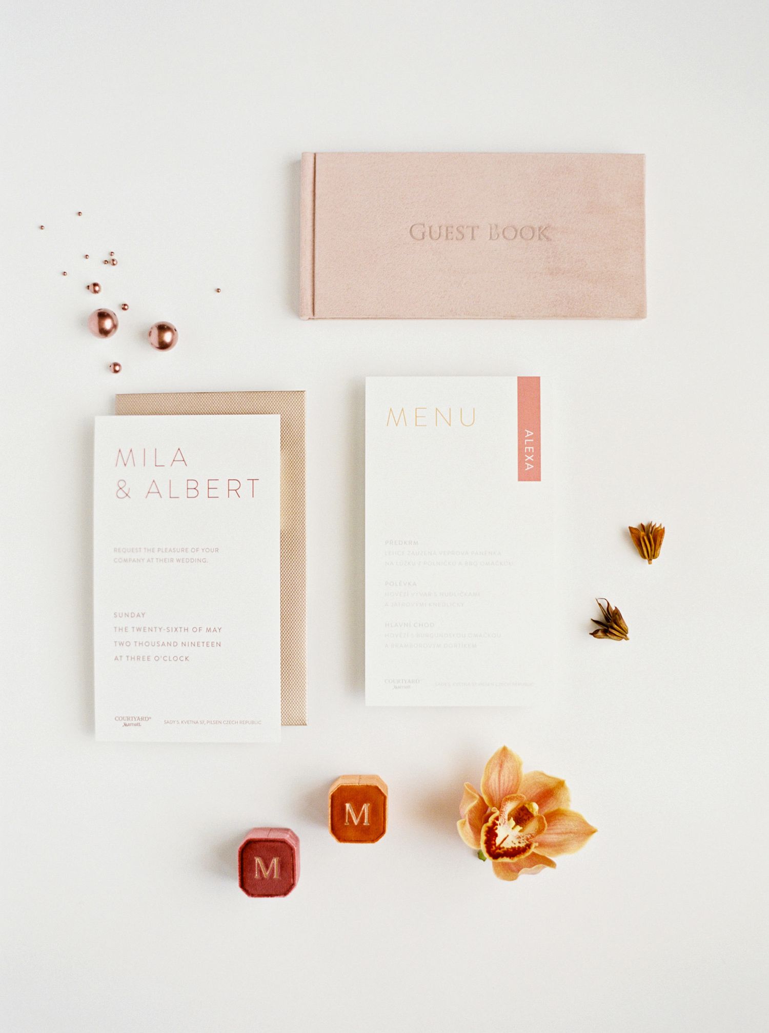 Elegant wedding invitation, card, and items displayed on white surface.