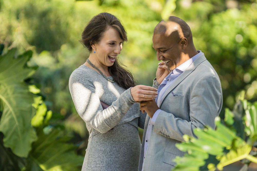 A joyful couple examining something special in their hands while standing in a garden.