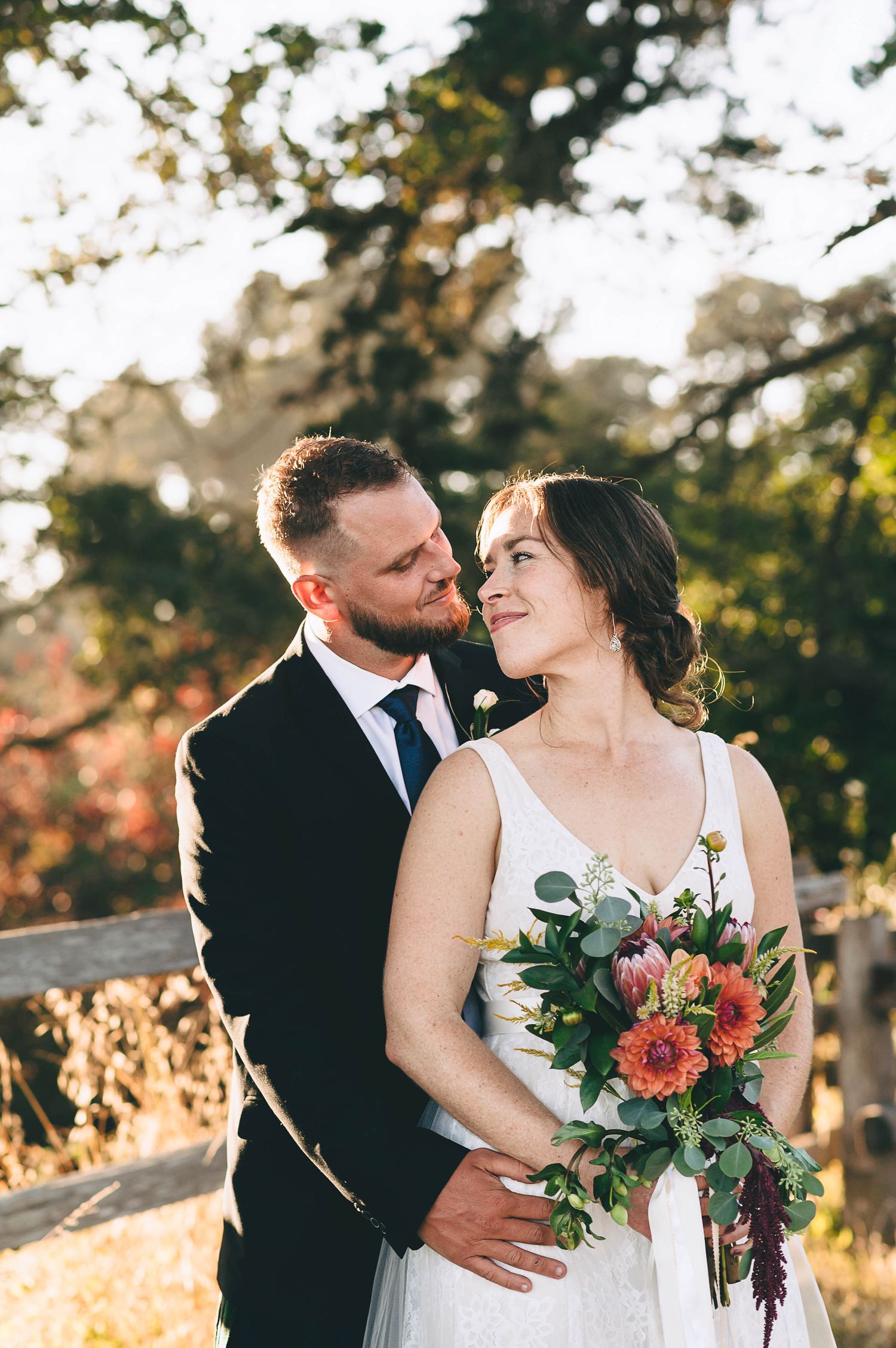 Bride and groom in field at sunset
