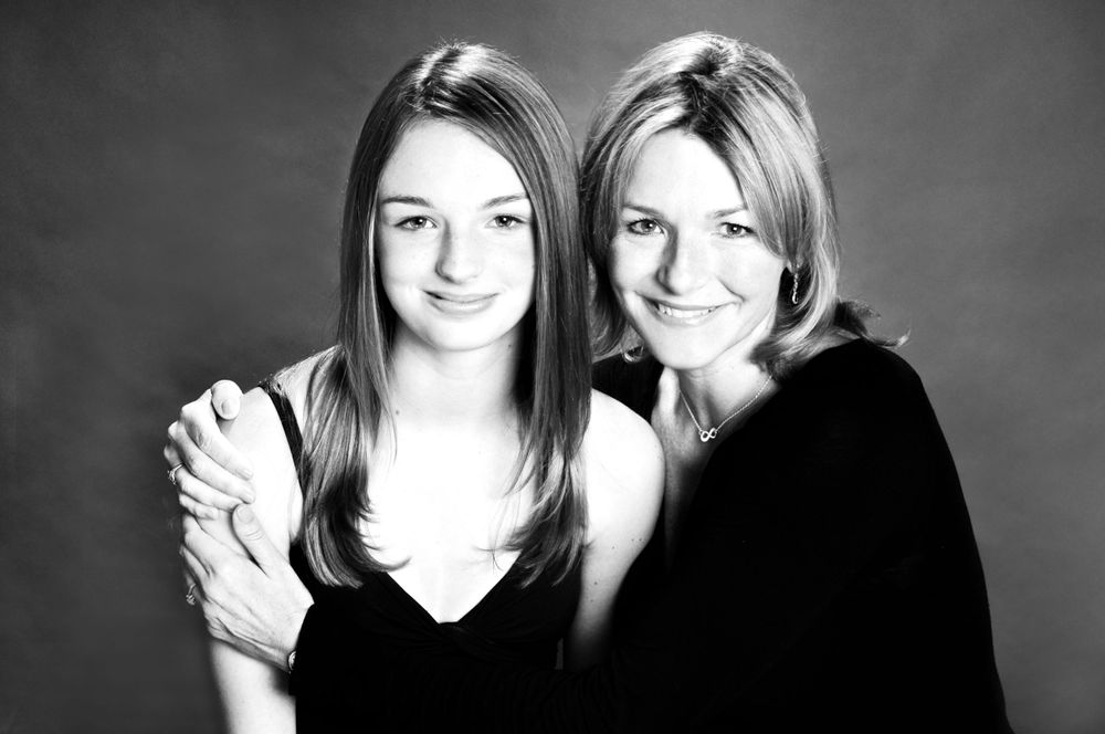 Black and white studio portrait of two people in dark clothing.