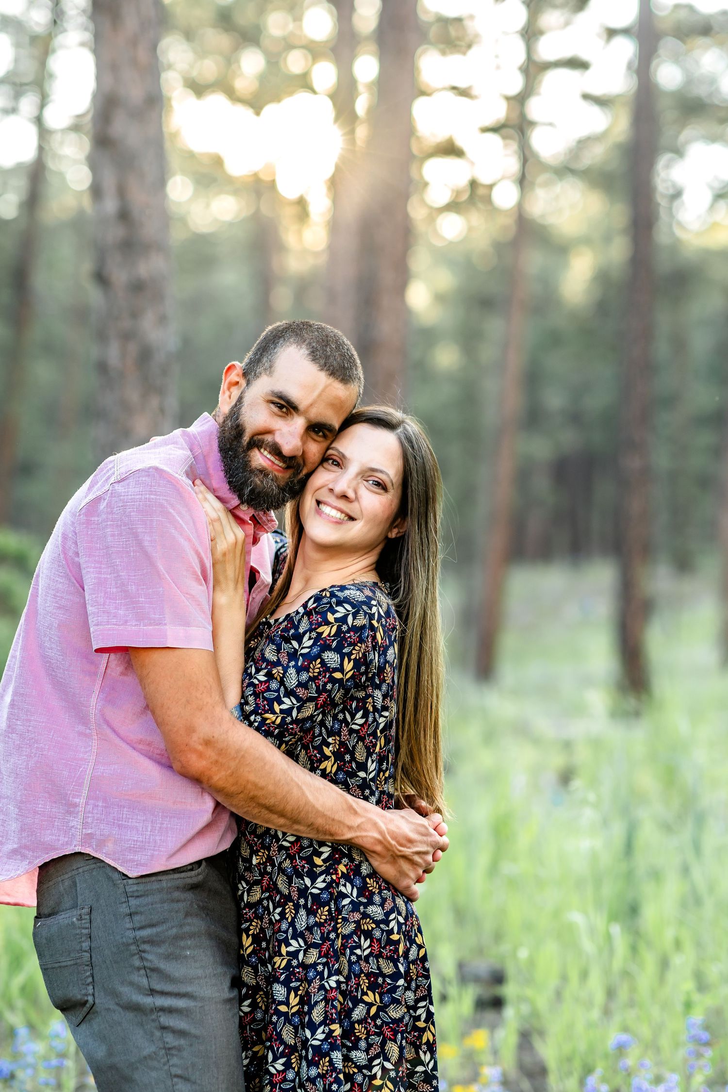 Dad brings mom in close and they smile at the camera during their family session in Colorado Springs.