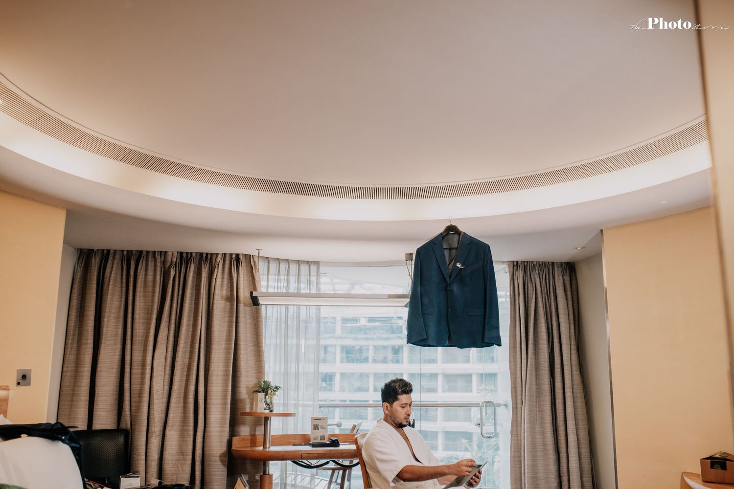 Elegant hotel room interior with curved ceiling and floor-to-ceiling windows.