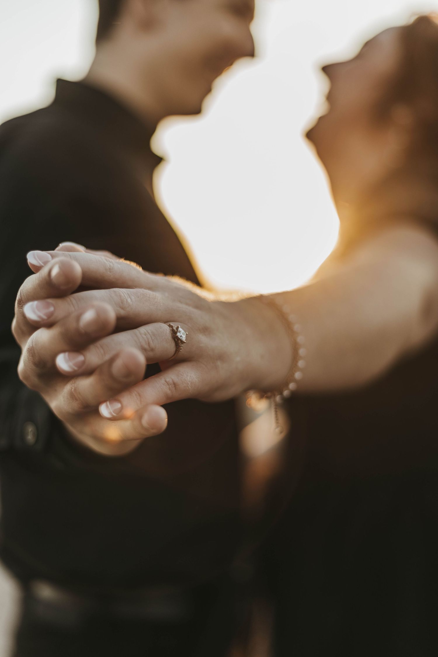 Couple holding hands with ring shot