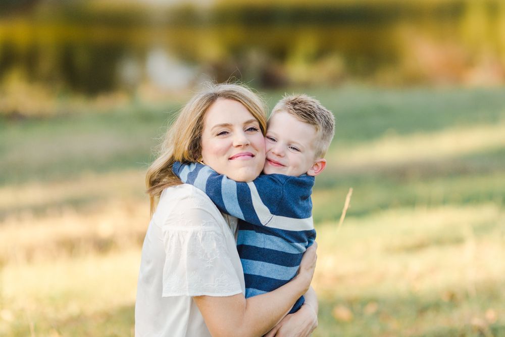 Heartwarming embrace between parent and child outdoors in golden sunlight.