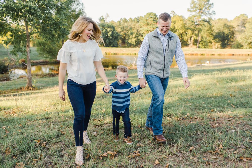 Family walking together and holding hands in a scenic outdoor setting during golden hour.