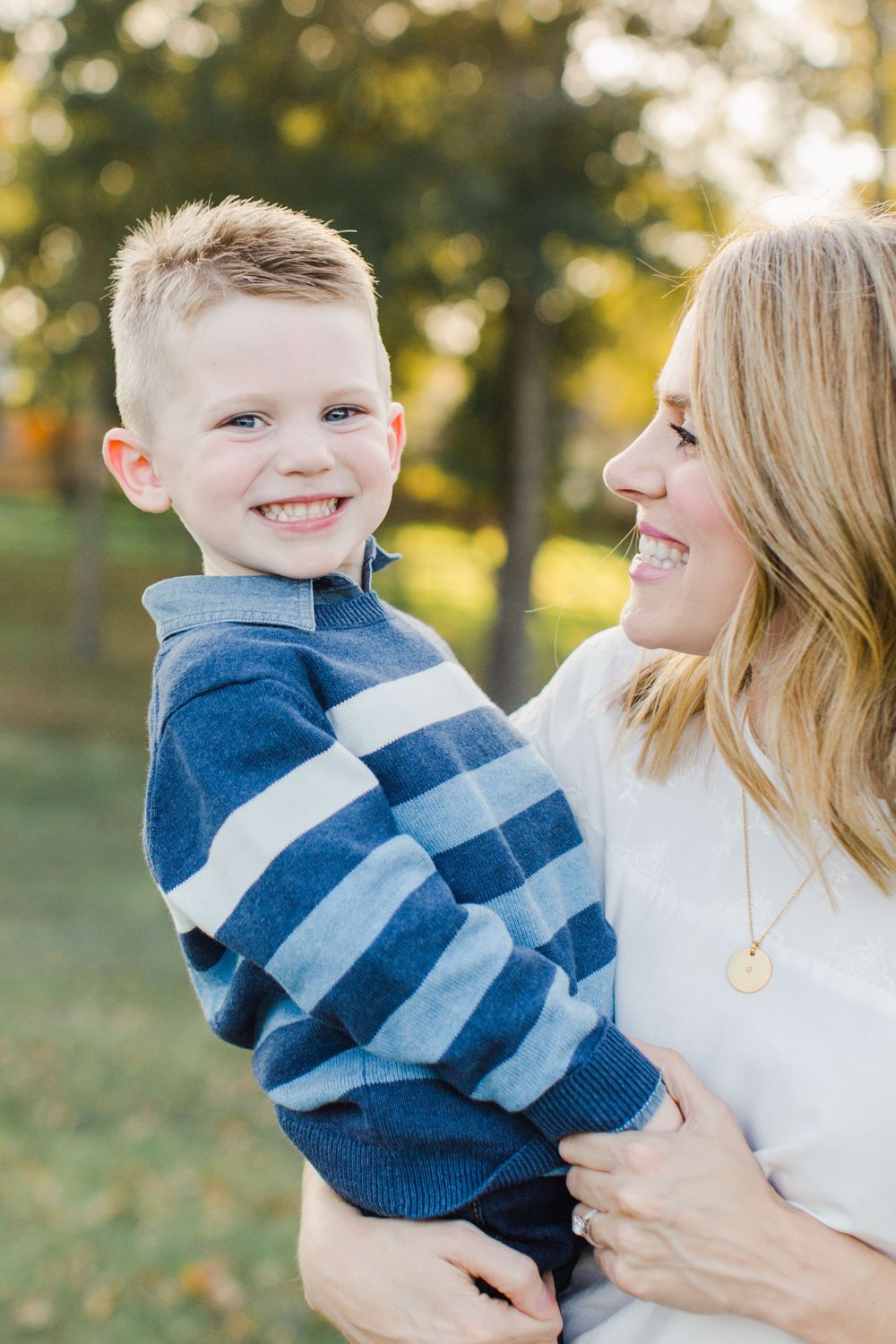 A tender moment between parent and child outdoors in warm evening light.