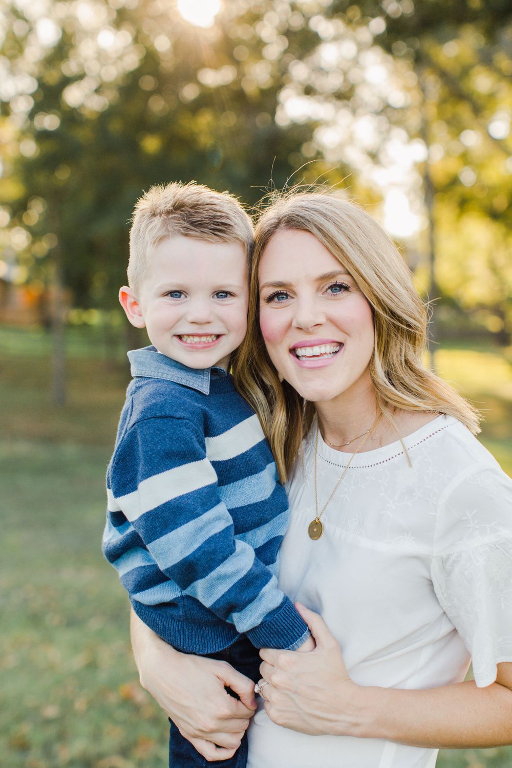 A sweet portrait of parent and child embracing outdoors during golden hour.