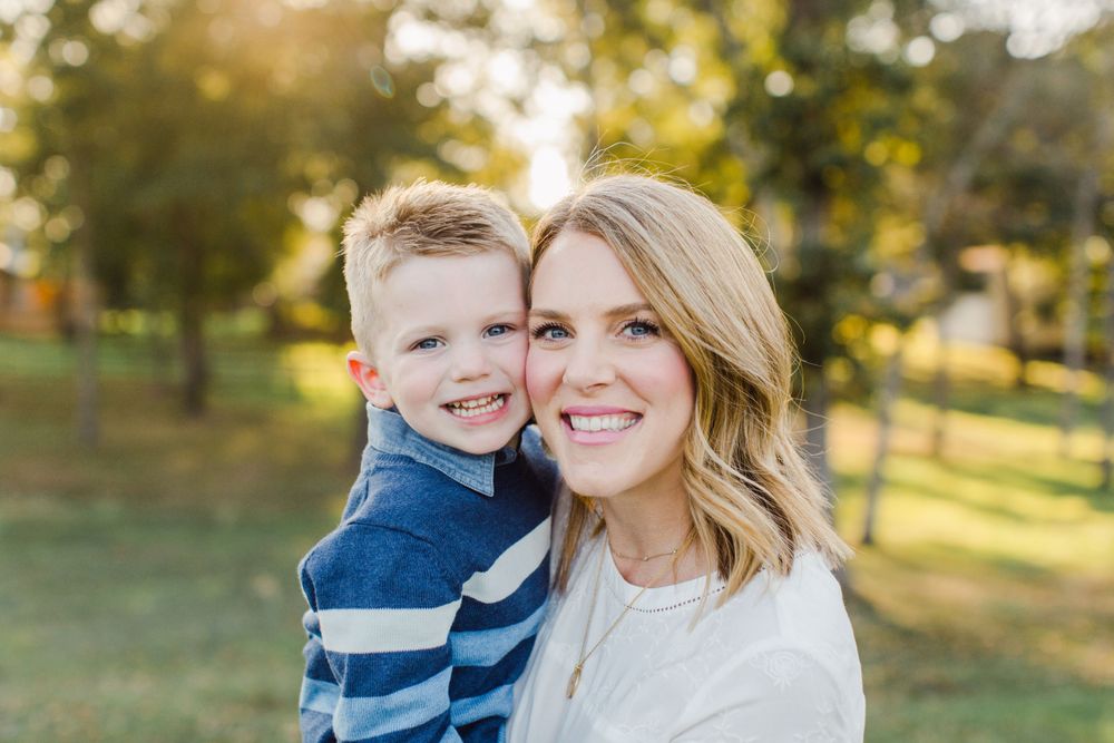 A heartwarming portrait of parent and child smiling together in autumn sunlight.