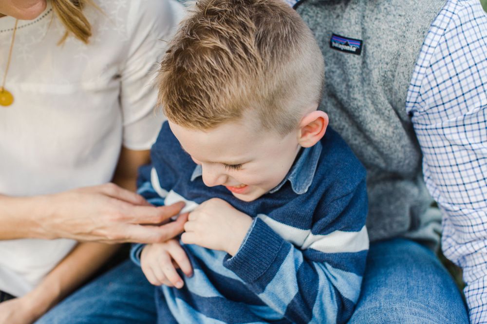 A candid moment of playfulness and laughter captured during a casual family photoshoot.