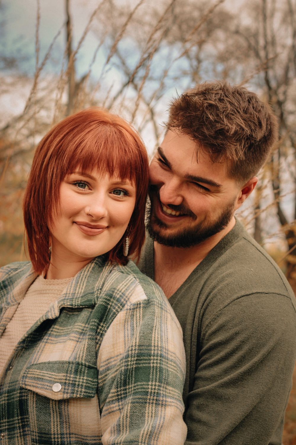 A close-up autumn engagement photo showing a couple's tender moment.