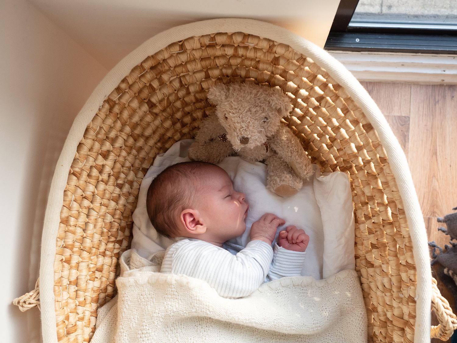 a baby sleeps in a moses basket