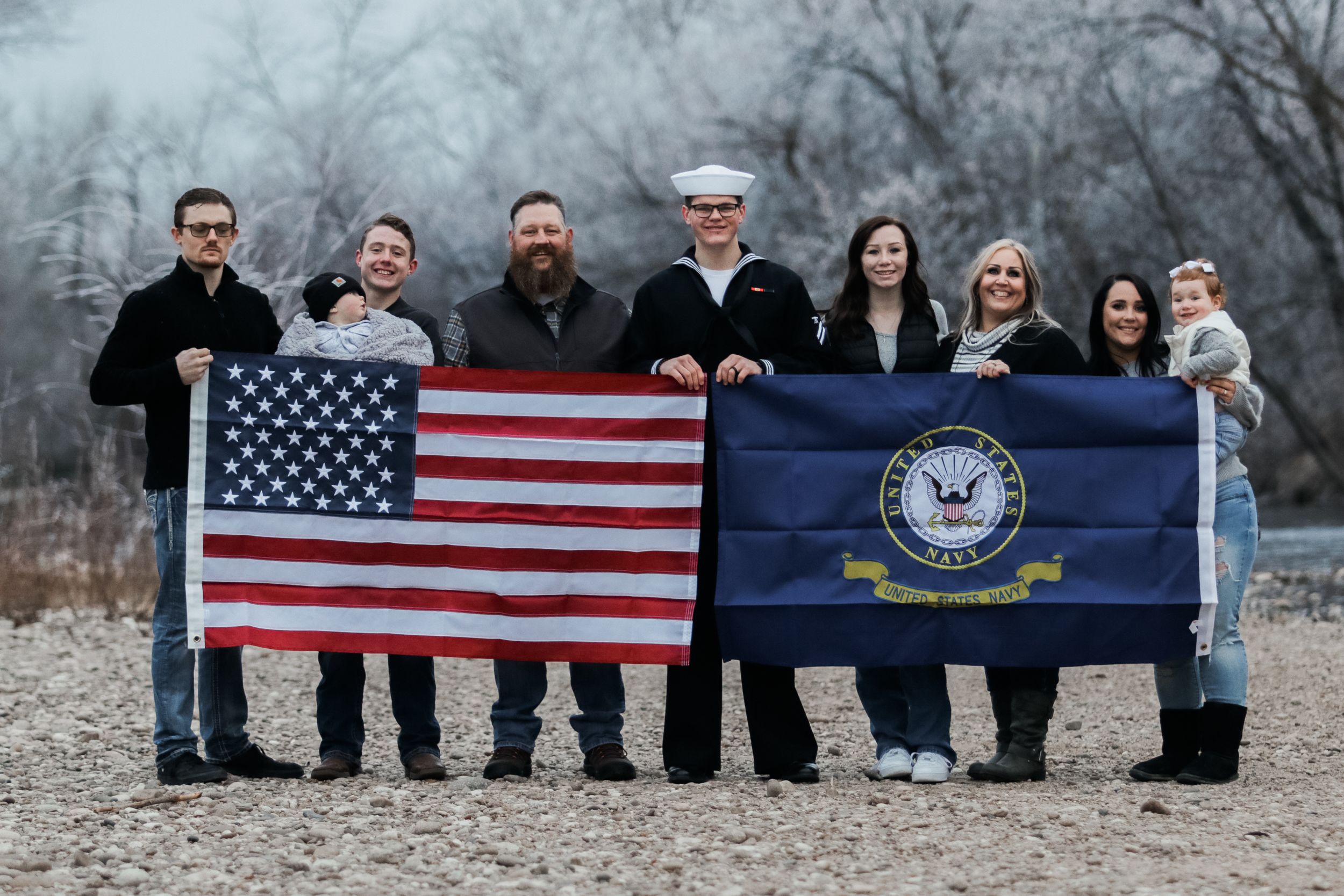 Group photo with American flags displayed against winter landscape.