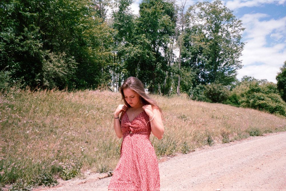 Summer outdoor shoot featuring scenic path and blue sky with white clouds.
