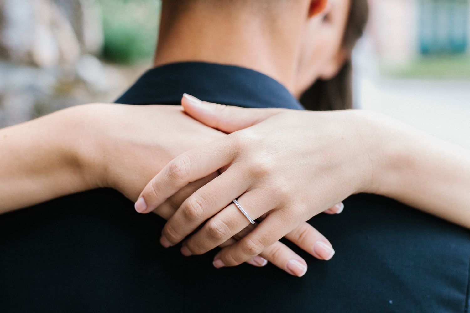Close-up of hands with wedding ring embracing in romantic gesture.