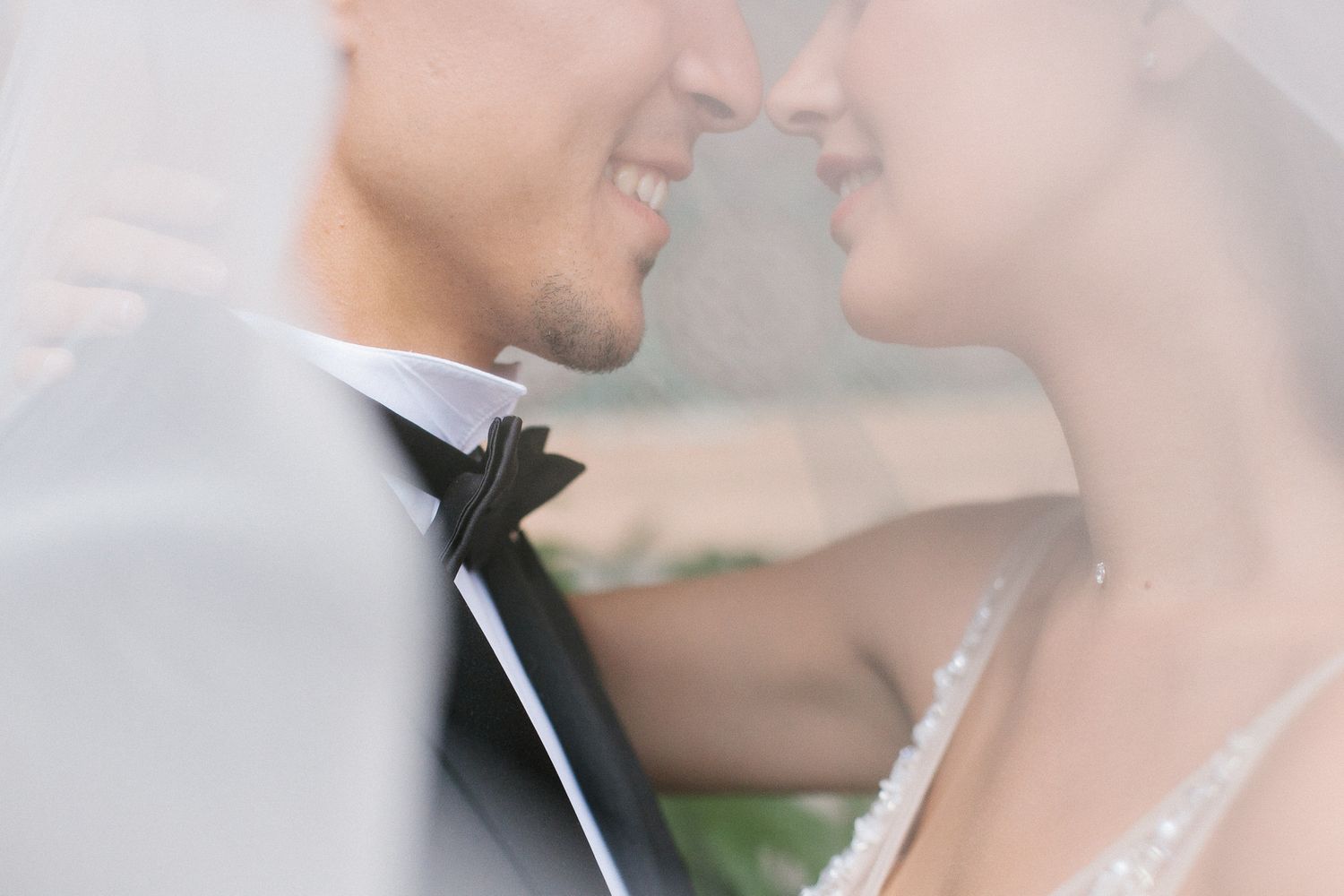 Romantic close-up wedding portrait through delicate white veil.
