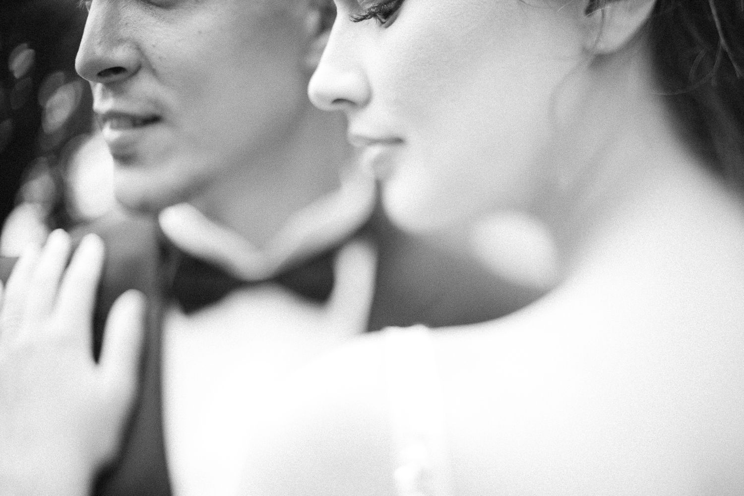 Close-up profile view of newlyweds sharing an intimate moment in black and white.