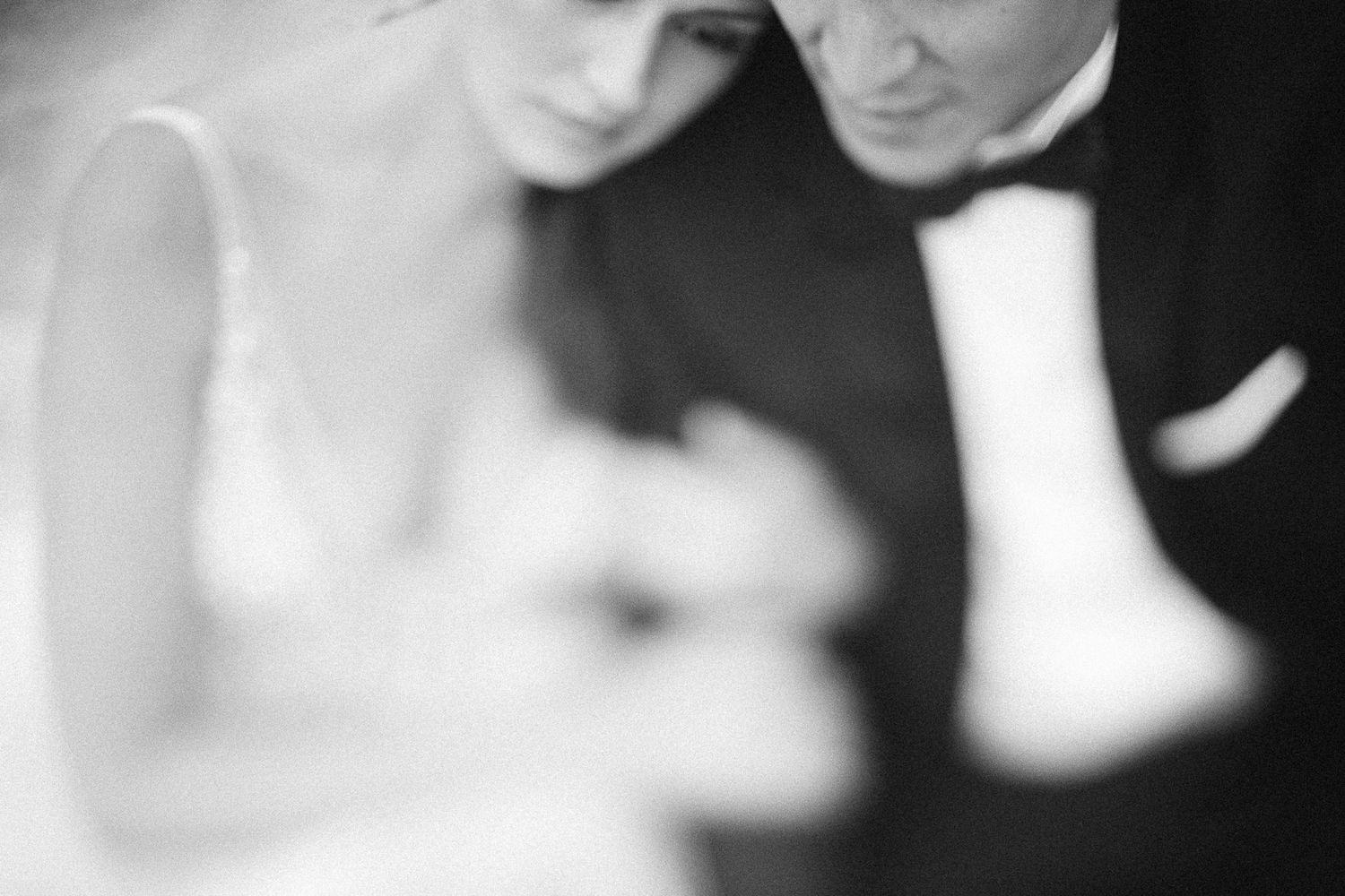 Artistic black and white close-up of a couple in formal attire.
