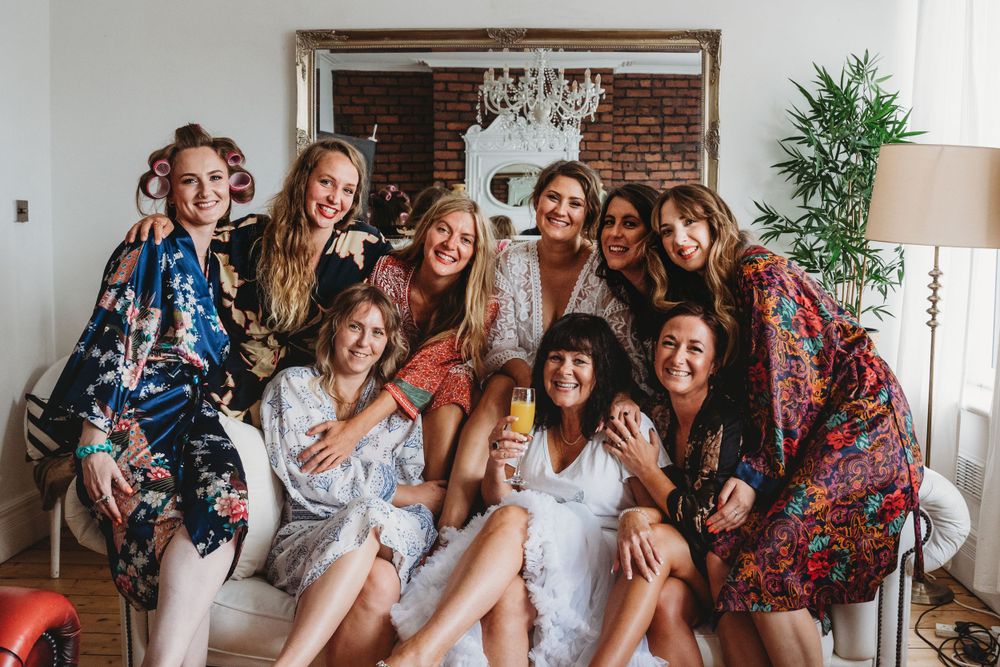 A celebratory group photo of wedding party members in floral dresses.