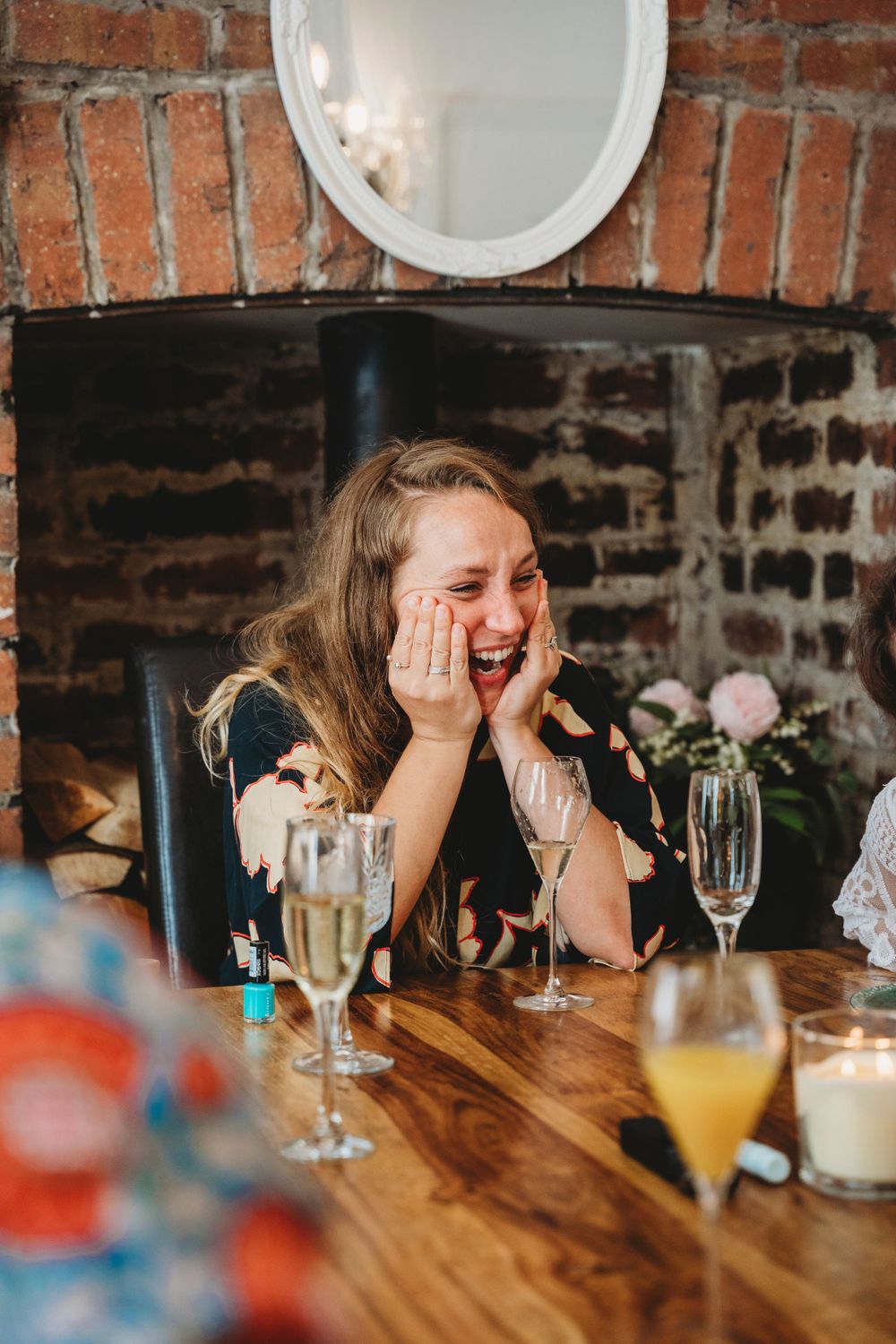 Emotional candid moments captured at a wooden table with drinks and champagne glasses.