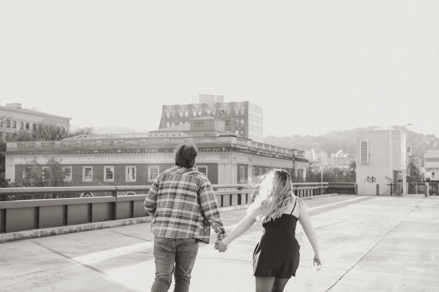 Winter engagement session in urban setting with industrial architecture.
