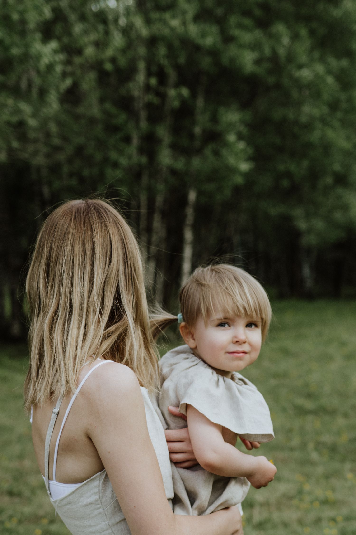 A tender moment captured between parent and child in a serene forest setting.