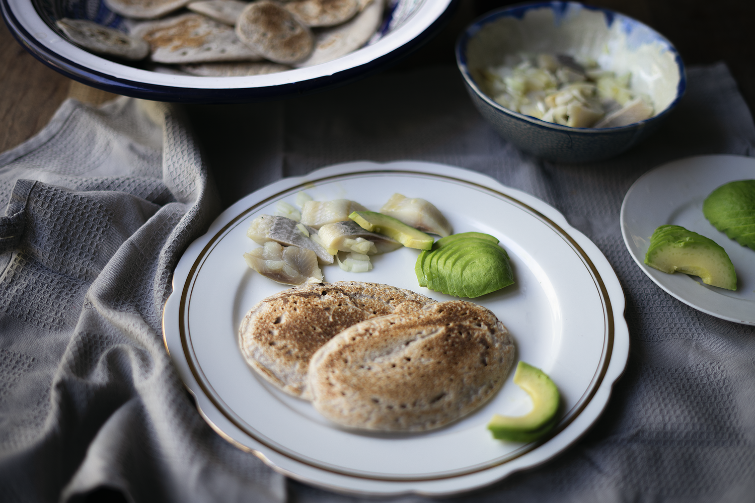 Plated chicken dish garnished with lime slices and side dishes on white ceramic plate.