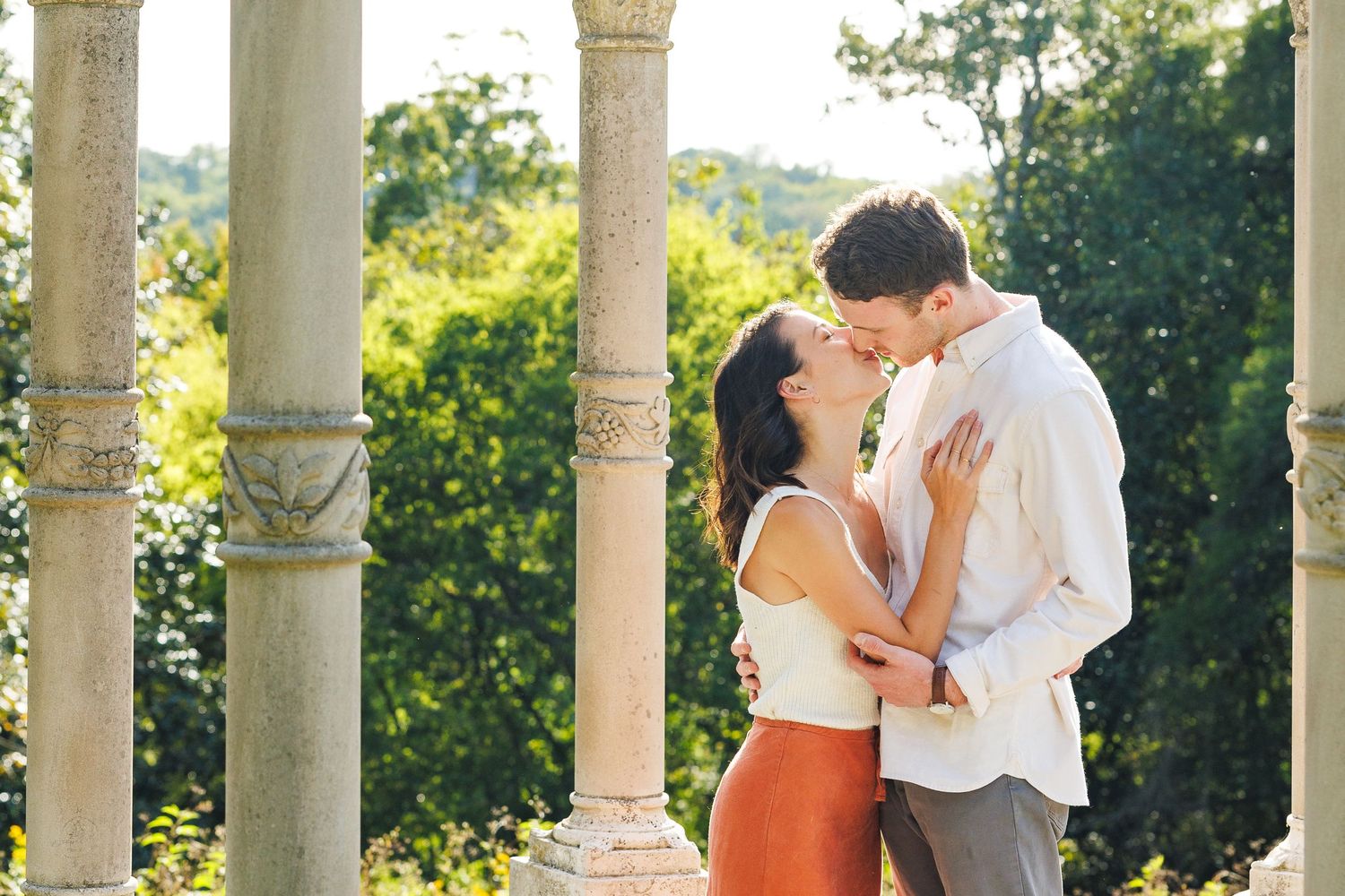 Engagement couple kissing under a gazebo at Maymont Park