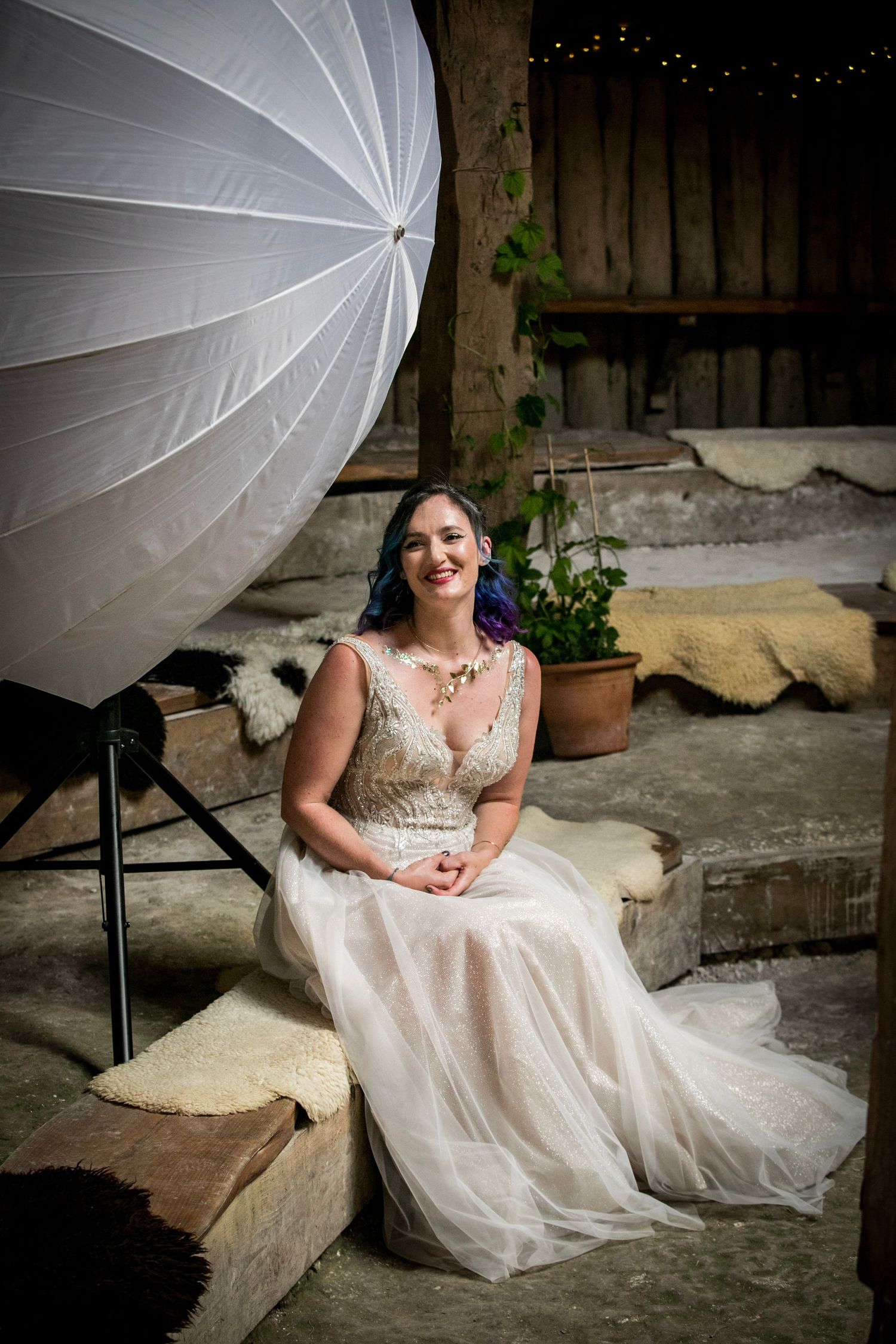 White wedding dress photographed with dramatic lighting and umbrella reflector.
