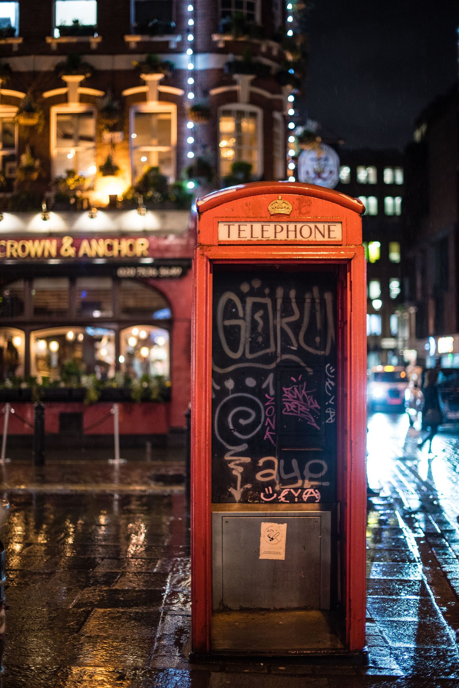 London's famous red telephone booth on a rainy night at Crown & Anchor