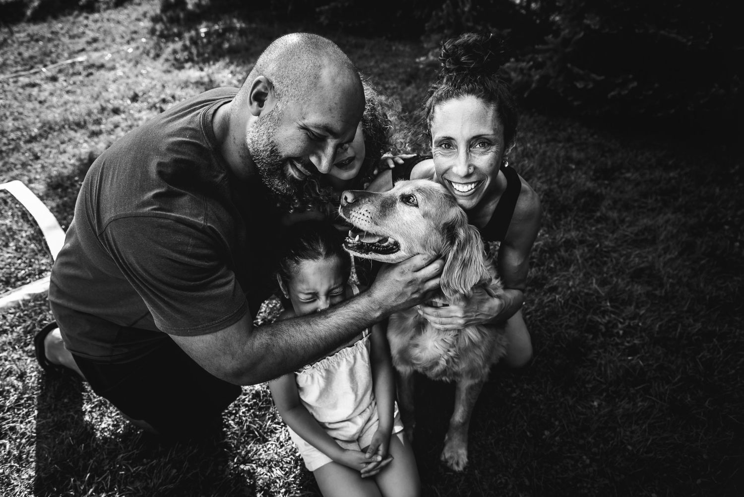 BW image of a family holding one another and their dog.