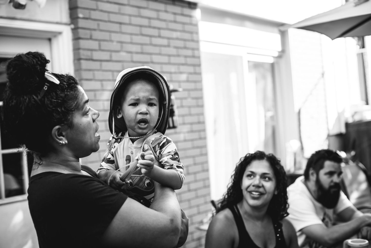 BW image of a woman holding a little boy in his arms.