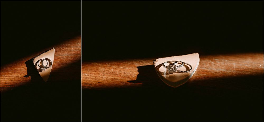Wedding rings casting dramatic shadows on polished wooden surface in artistic composition.