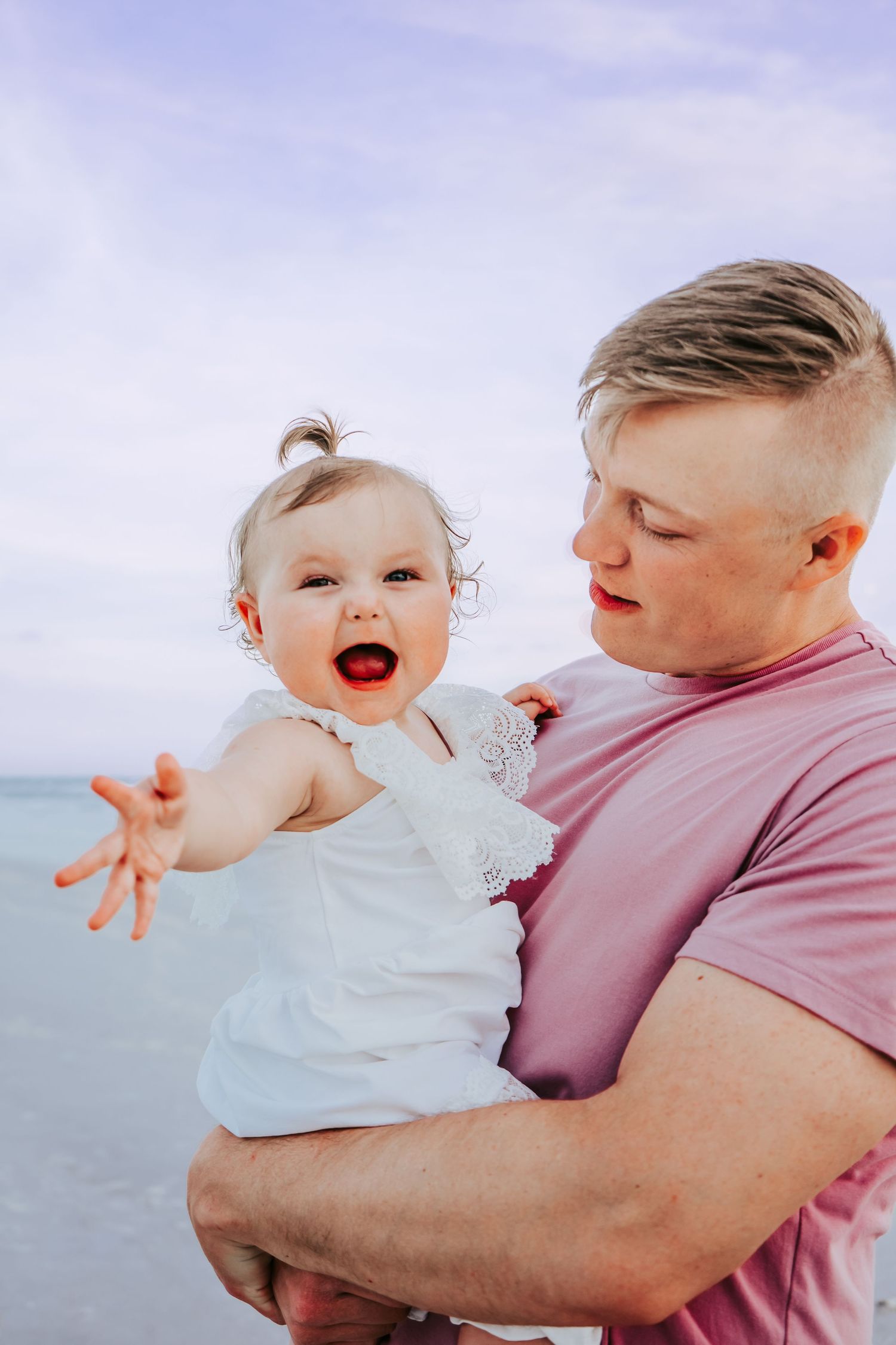 Outdoor Family Session at Indian Rocks Beach in Indian Rocks, FL; baby in fathers arms on beach