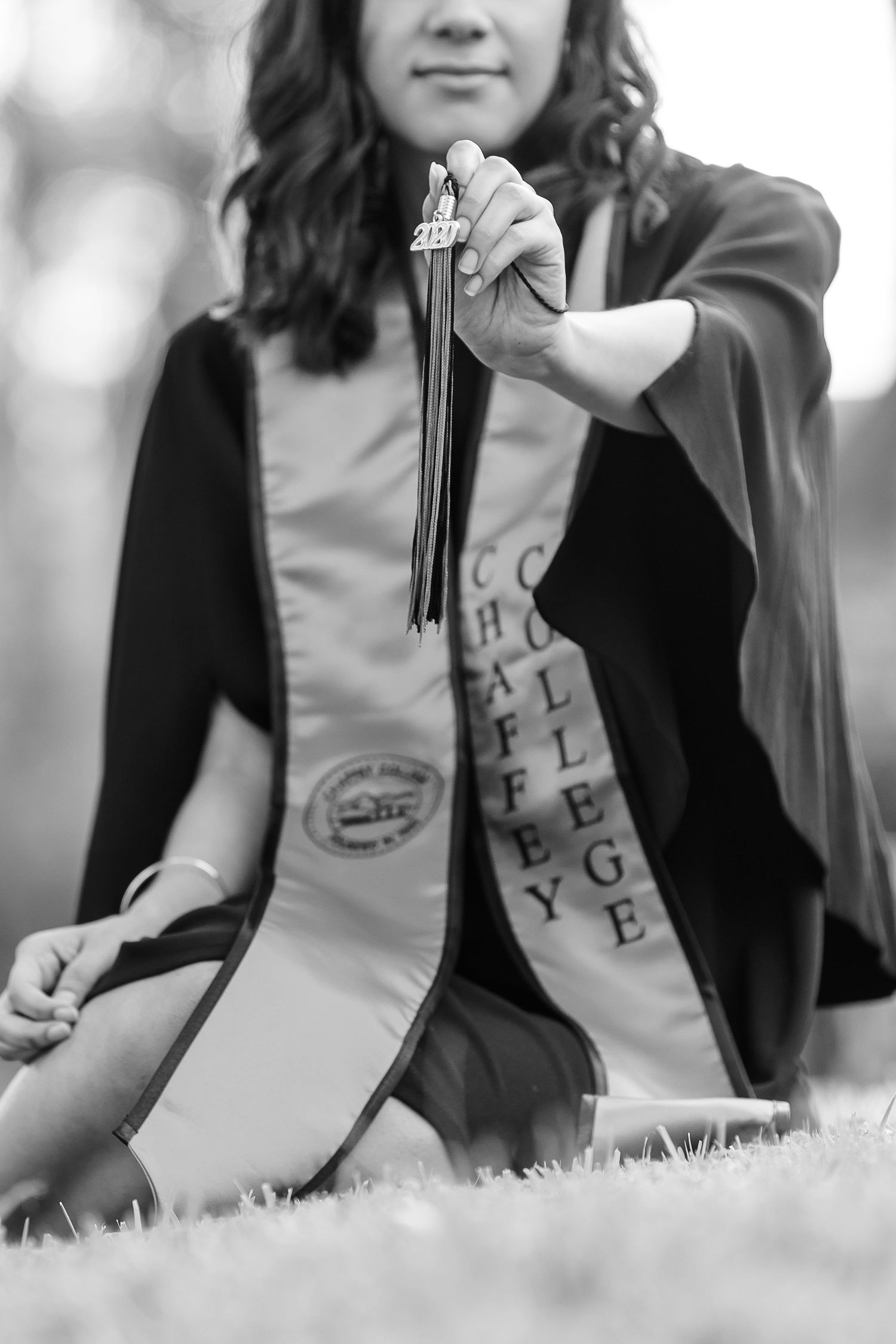 Girl holding college tassel and wearing a sash