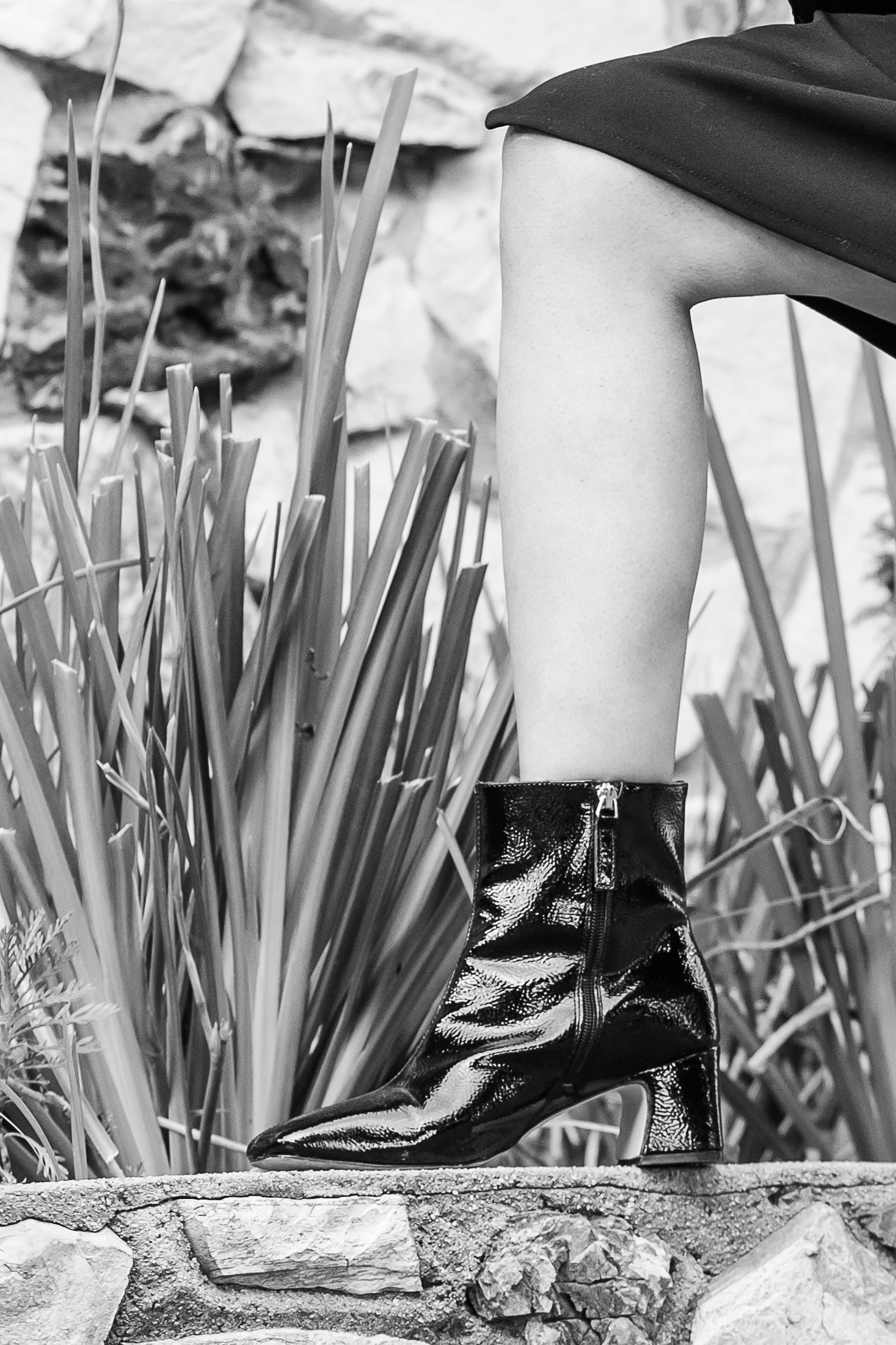 Black and White close up of black boots and a leg