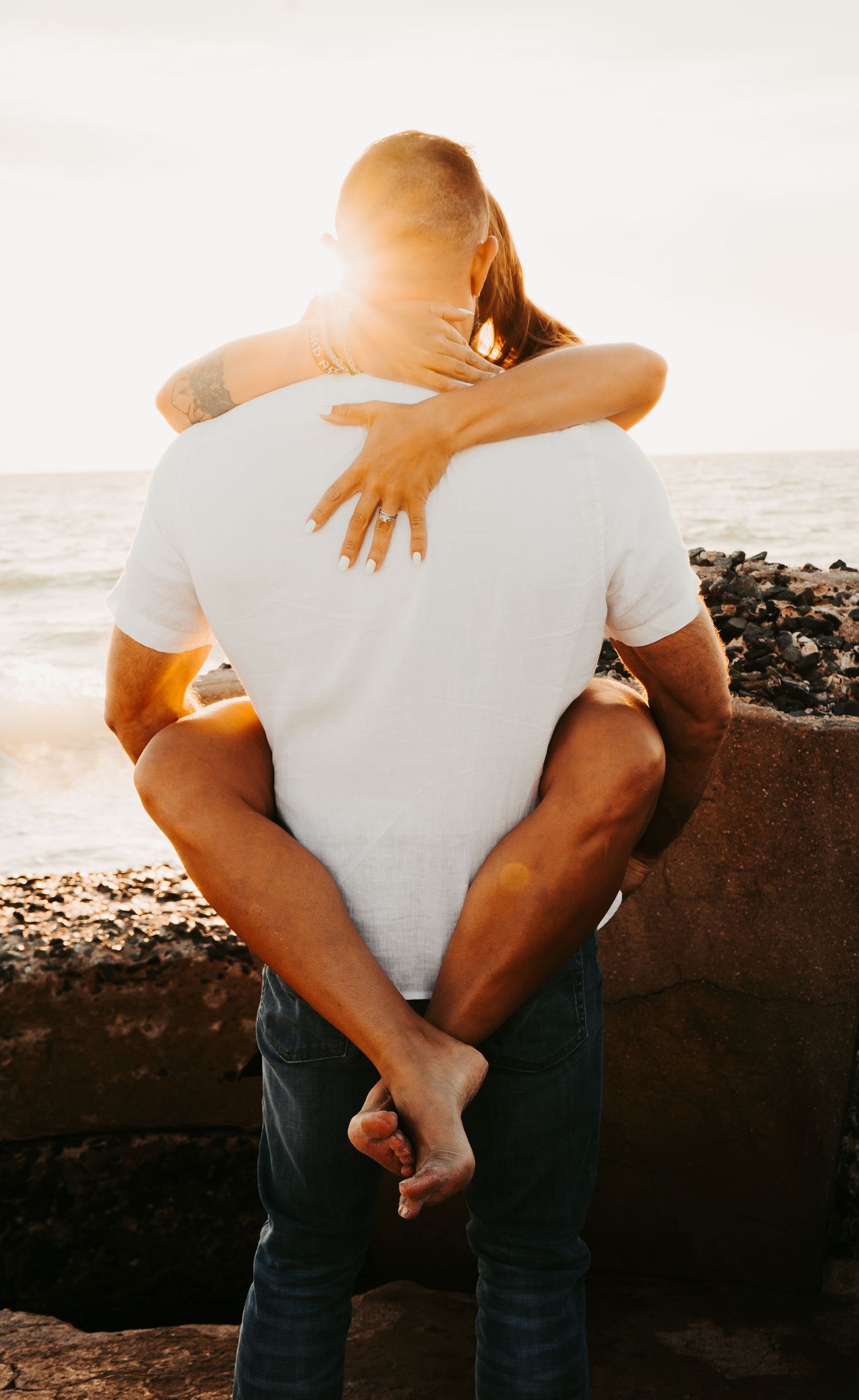 Outdoor Engagement Session Ft. Desoto, St. Pete, FL; Couple embracing at sunset with sunflair