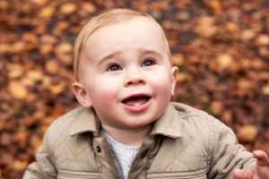 Baby boy photographed in autumnal leaves