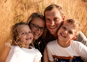 Family of four closeup portrait smiling at the camea