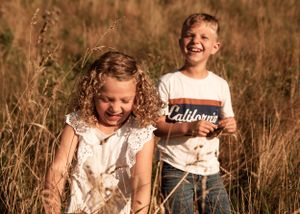 Siblings photo laughing in the long grass